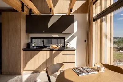 a kitchen and dining room with a table and chairs at NALAS domki z widokiem in Rabka