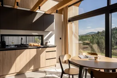 a kitchen with a table and chairs and a large window at NALAS domki z widokiem in Rabka