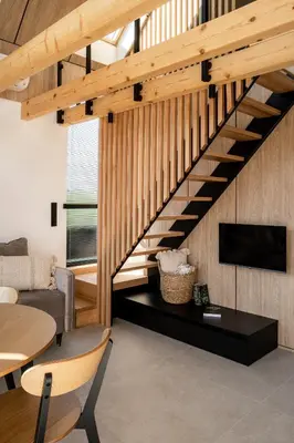 a staircase in a living room with a couch and a tv at NALAS domki z widokiem in Rabka