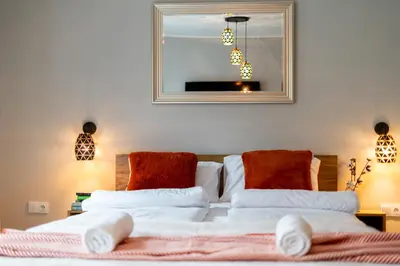 a bedroom with a bed with white sheets and red pillows at Malila Premium Apartments Cracow Centre Grzegórzecka 15 in Kraków
