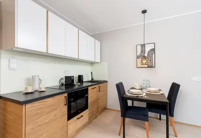 a kitchen with a table and a dining room at Malila Premium Apartments Cracow Centre Grzegórzecka 15 in Kraków