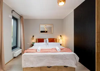 a bedroom with a large bed and a window at Malila Premium Apartments Cracow Centre Grzegórzecka 15 in Kraków