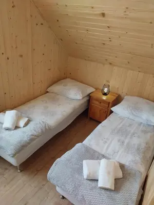 a room with two beds in a wooden cabin at Relaksówka in Roztoka