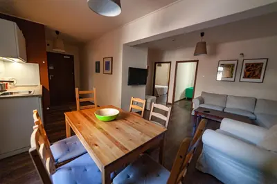 a living room with a red couch and a kitchen at Lounge Apartments in Kraków