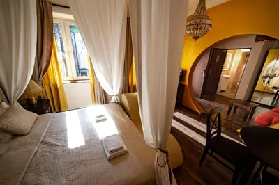 a bedroom with a bed and a table and a mirror at Lounge Apartments in Kraków
