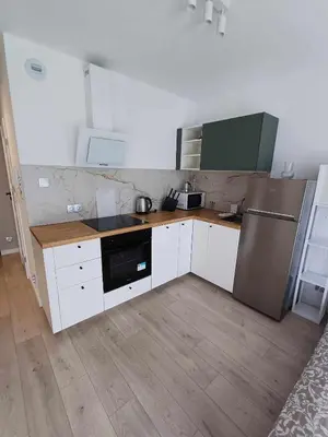 a kitchen with white cabinets and a stainless steel refrigerator at Wielicka Apartment 3 in Kraków