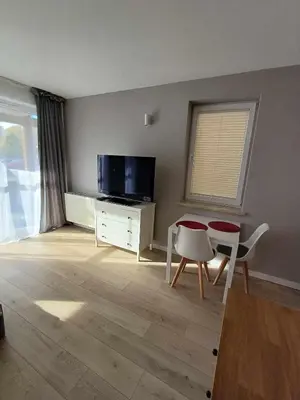a living room with a tv and a table and chairs at Wielicka Apartment 3 in Kraków