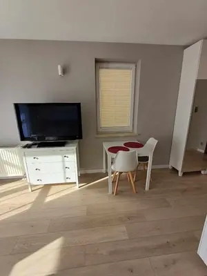 a living room with a television and a table and chairs at Wielicka Apartment 3 in Kraków