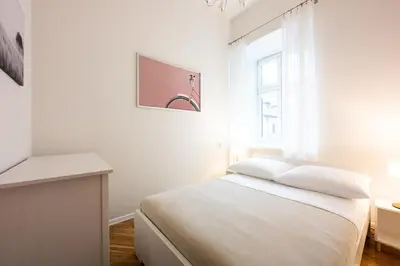a white bedroom with a bed and a window at Native Apartments Skawińska 5 in Kraków