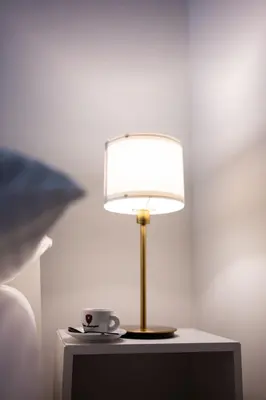 a lamp on a table with a cup on it at Native Apartments Skawińska 5 in Kraków