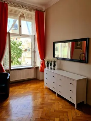 a room with a dresser with a mirror and two windows at Royal Palace from the 14th century - 125 m2 in Kraków