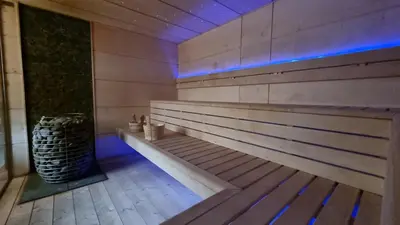 a wooden bench in a room with a trash can at Emerald Spa Guest house in Kraków