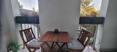 a wooden table and two chairs on a balcony at Emerald Spa Guest house in Kraków