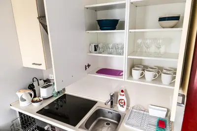 a kitchen with a sink and white cabinets at Bulwar Kurlandzki Vistula Apartment by BookingHost in Kraków