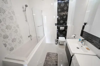 a white bathroom with a shower and a sink at Bulwar Kurlandzki Vistula Apartment by BookingHost in Kraków