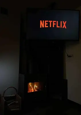 a fireplace with a sign that reads netflix at Domek Leo's House in Jaszczurowa