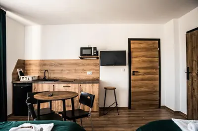 a room with a table and a kitchen with a small table at Apartamenty W Centrum Chrzanowa in Chrzanów