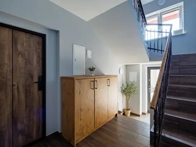 a room with a wooden cabinet and a staircase at Apartamenty W Centrum Chrzanowa in Chrzanów