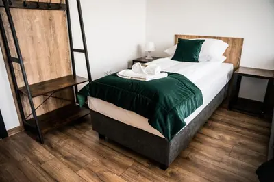a bedroom with a large bed with a green blanket at Apartamenty W Centrum Chrzanowa in Chrzanów
