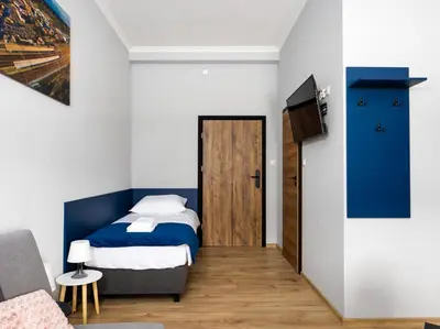 a bedroom with a bed and a tv and a door at Apartamenty W Centrum Chrzanowa in Chrzanów