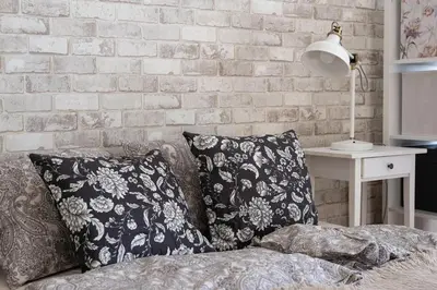 a bedroom with a brick wall and a bed with pillows at Negroni Apartments Plac Nowy in Kraków