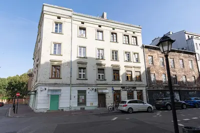 a white building with a car parked in front of it at Negroni Apartments Plac Nowy in Kraków