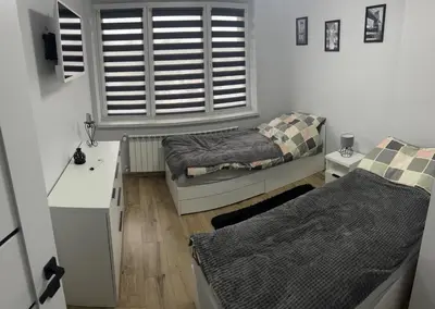 a small room with two beds and a window at Apartament ,,Eden” in Zator