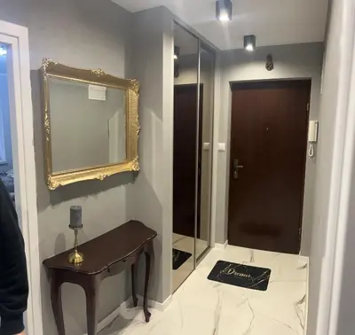 a bathroom with a mirror and a wooden table at Apartament ,,Eden” in Zator