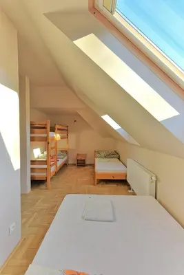 a attic bedroom with two bunk beds and a window at Agroturystyka Podzamcze in Krzeszowice