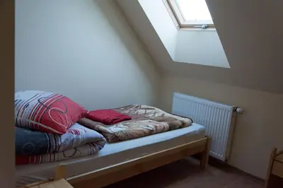 a bed with two red pillows on it in a room at Agroturystyka Podzamcze in Krzeszowice