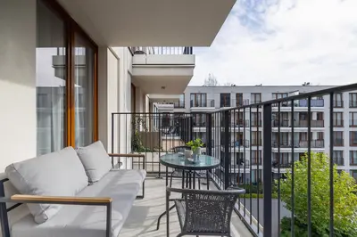 a balcony with a couch and a table on a balcony at GO Apartments Studio with Balcony Rakowicka Cracow by Noclegi Renters in Kraków