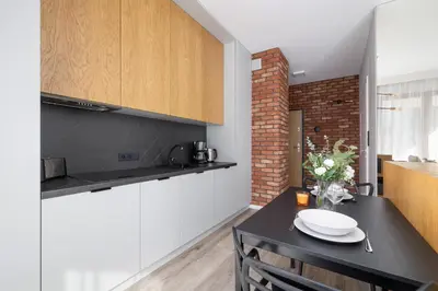 a kitchen and dining room with a black table and chairs at GO Apartments Studio with Balcony Rakowicka Cracow by Noclegi Renters in Kraków