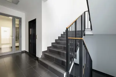 a staircase in a house with black tile floors at GO Apartments Studio with Balcony Rakowicka Cracow by Noclegi Renters in Kraków