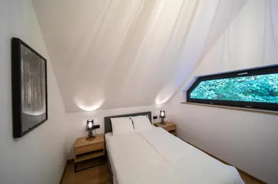 a bedroom with a white bed and a window at Błaż Apart in Laskowa