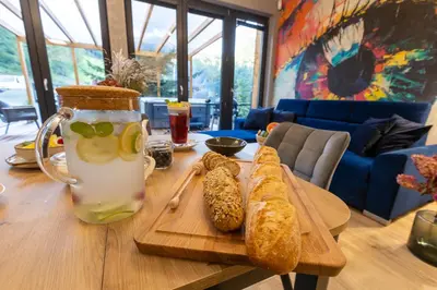 a table with a drink and some bread on a tray at Błaż Apart in Laskowa
