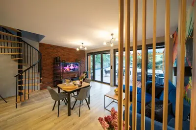 a dining room and living room with a dining table at Błaż Apart in Laskowa
