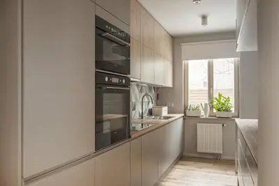 a kitchen with white cabinets and black appliances at Charming Apartment with Garden, only 1 km to Wawel Castle by Noclegi Renters in Kraków