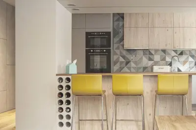 a kitchen with a counter with yellow bar stools at Charming Apartment with Garden, only 1 km to Wawel Castle by Noclegi Renters in Kraków