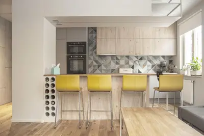 a kitchen with a counter and yellow bar stools at Charming Apartment with Garden, only 1 km to Wawel Castle by Noclegi Renters in Kraków