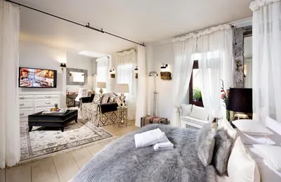 a bedroom with a large bed and a living room at Kanonicza 22 in Kraków