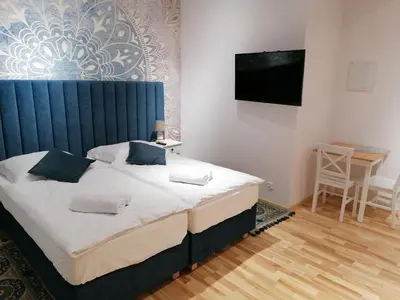a bedroom with a bed with a blue headboard at Juwel Apartments Kraków 14 in Kraków
