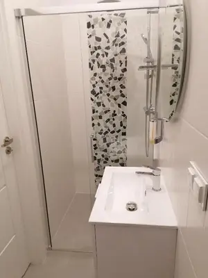 a white bathroom with a sink and a shower at Juwel Apartments Kraków 14 in Kraków