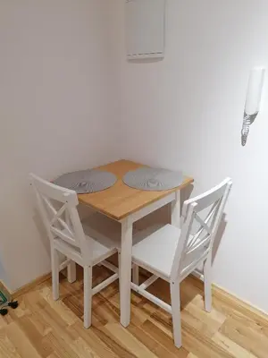 a wooden table and two chairs and a table and chairs at Juwel Apartments Kraków 14 in Kraków