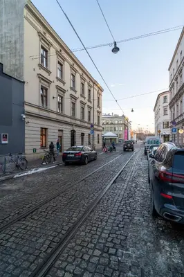 a cobblestone street with cars parked on the street at Kraków Comfort Loft Apartments by Rentujemy in Kraków