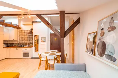 a kitchen and dining room with a table and chairs at Kraków Comfort Loft Apartments by Rentujemy in Kraków