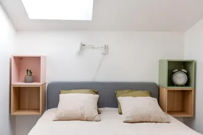 a bedroom with a bed with two pillows and a clock at Kraków Comfort Loft Apartments by Rentujemy in Kraków