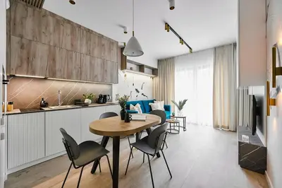 a kitchen and dining room with a table and chairs at Golden Dreams Luxury Apartments 103 in Kraków