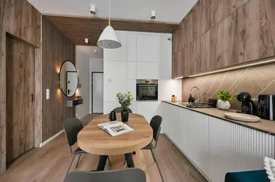 a kitchen and dining room with a wooden table at Golden Dreams Luxury Apartments 103 in Kraków