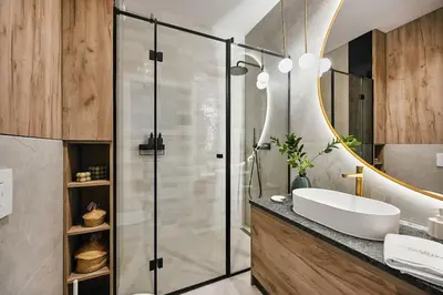 a bathroom with a sink and a glass shower at Golden Dreams Luxury Apartments 103 in Kraków