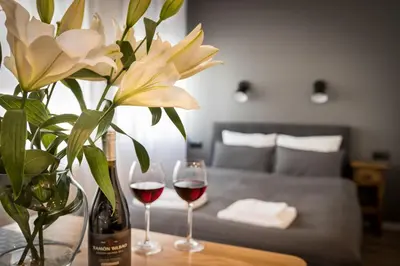 a table with two glasses of wine and a vase with flowers at NEW APARTMENT! Jewish quarter! in Kraków